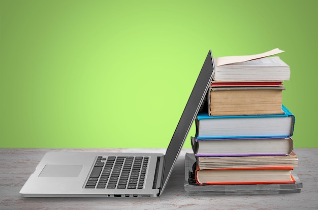 Pile de livres avec ordinateur portable sur table en bois