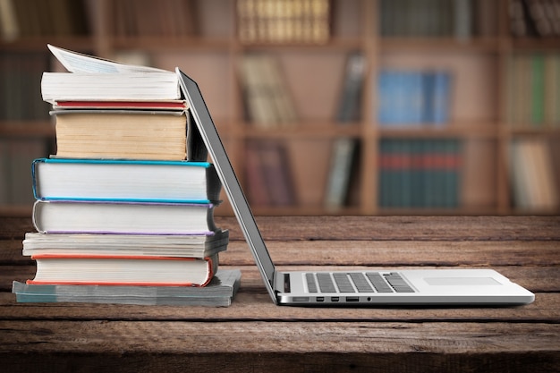 Pile de livres avec ordinateur portable sur table