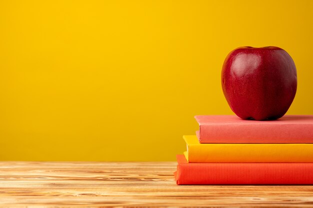 Pile de livres et pomme rouge sur 24