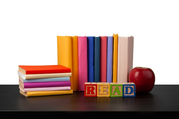 Pile de livres et pomme sur table contre fond blanc