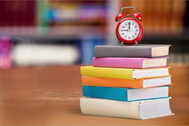 Pile de livres et réveil au bureau