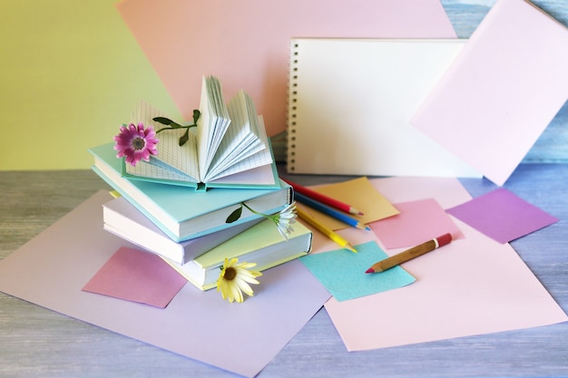Photo pile de livres avec des signets de papier coloré de fleurs sur la table