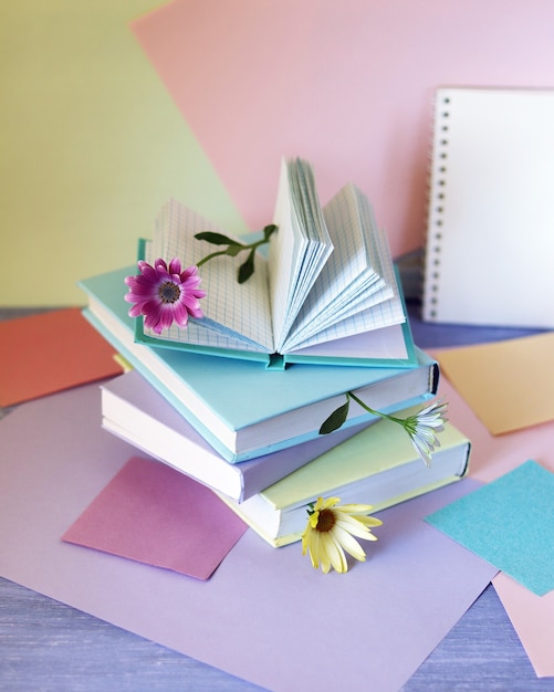 Pile de livres avec des signets de papier coloré de fleurs sur la table