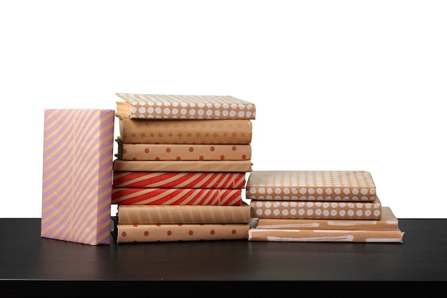 Pile de livres sur table en bois contre fond blanc