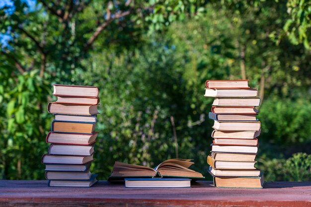Pile de livres sur une table en bois sur fond de nature à l'extérieur