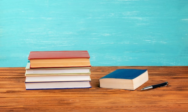 Une pile de livres sur une table en bois.