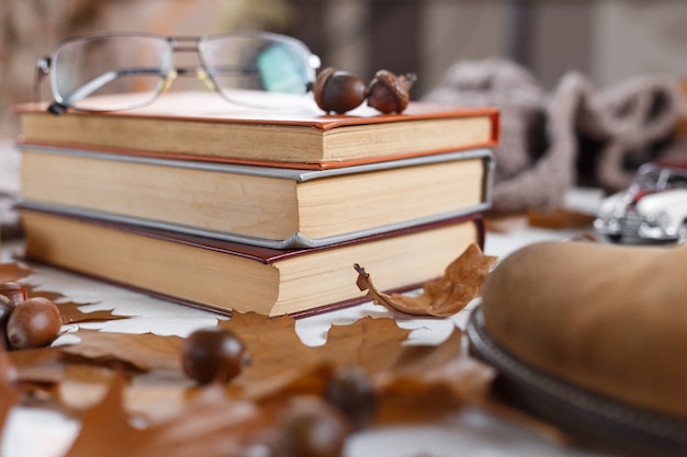 Pile de livres sur la table avec des lunettes posées sur le dessus. Notion d'éducation