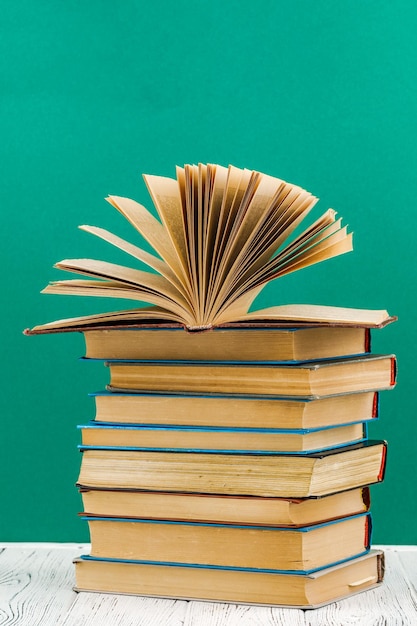 Une pile de livres sur un tableau blanc sur fond vert