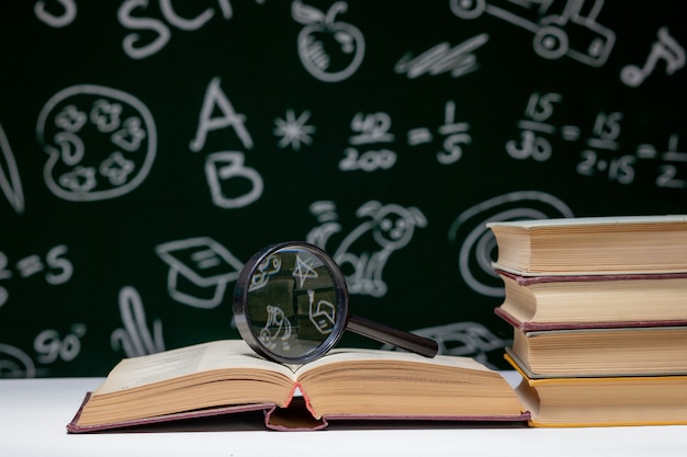 Pile de livres sur un tableau noir vert, concept de retour à l'école