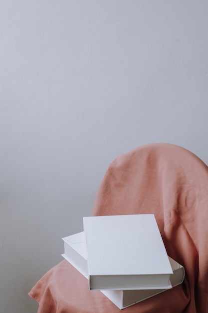 Pile de livres sur tissu rose pour maquette de livre sur fond gris