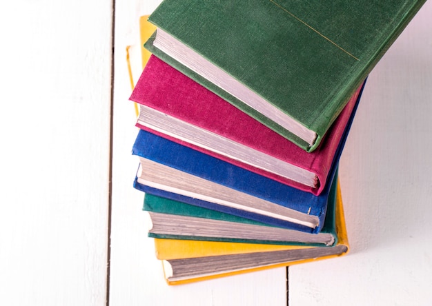 Pile de livres tourné en gros plan sur une table en bois blanc