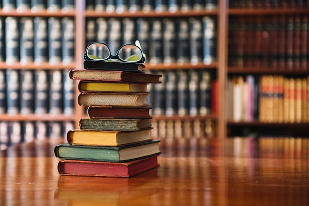 Photo pile de livres et de verres dans la bibliothèque