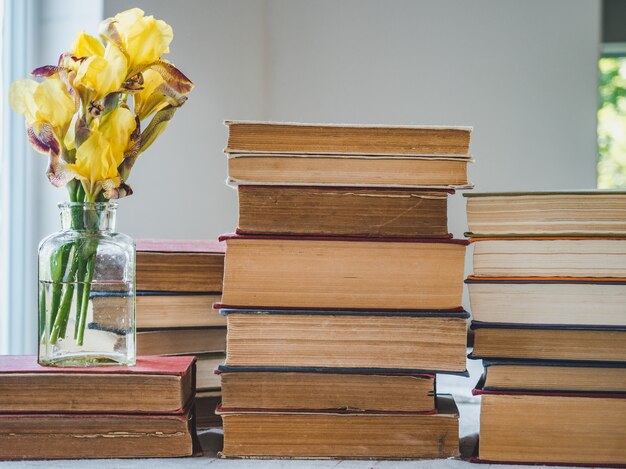 Pile de livres vintage et de belles fleurs