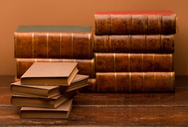 Pile de livres vintage sur table en bois avec fond marron