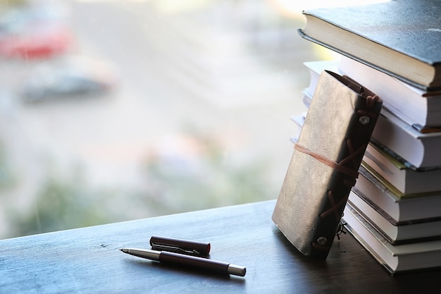 Photo une pile de manuels sur le rebord de la fenêtre et des ustensiles d'écriture