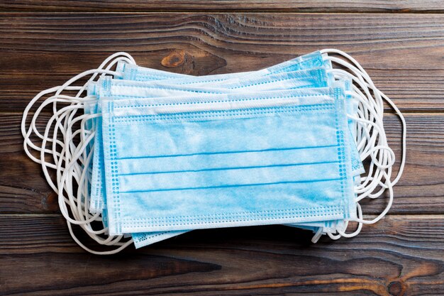 Pile de masques médicaux de protection sur table en bois. Syndrome respiratoire. Protégez votre concept de santé