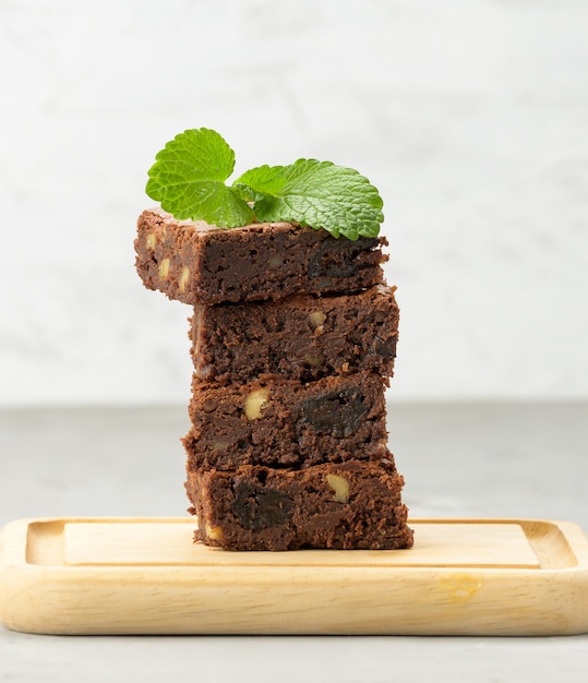 Pile de morceaux de tarte au chocolat brownie cuit au four sur planche de bois, délicieux dessert