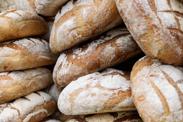 Pile de pains complets fraîchement cuits dans la boulangerie ou le marché fermier local