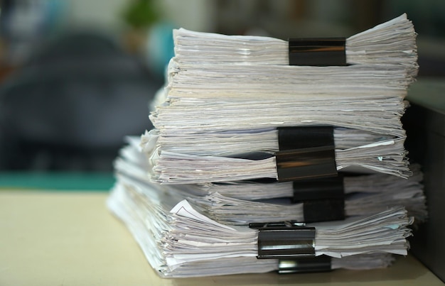 Pile de papier sur le bureau liée aux fonctions de l'entreprise Avec matin lightsoft focus