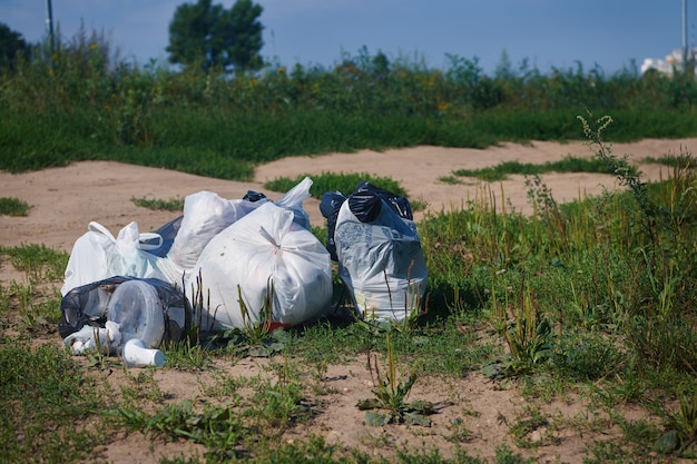 Pile de paquets d'ordures sur un terrain. Déchets de plastique. Concept de problème de recyclage des ordures et d'élimination des déchets.