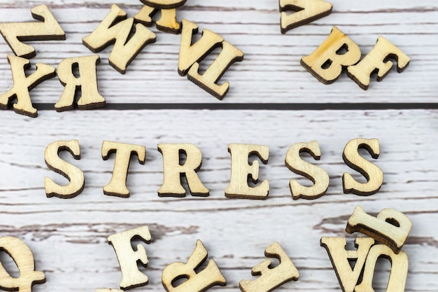 Une pile de petites lettres en bois sur une table sombre