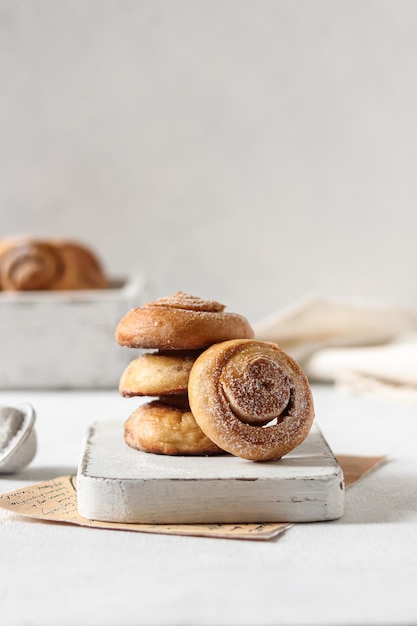 Une pile de petits pains à la cannelle sur une surface en marbre blanc.