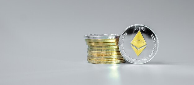 Pile de pièces d'argent ethereum sur fond gris