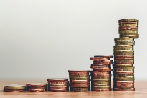 Une pile de pièces est bien disposée au-dessus d'une table en bois solide Une pile de monnaies créant un escalier montrant une inflation incrémentielle générée par l'IA