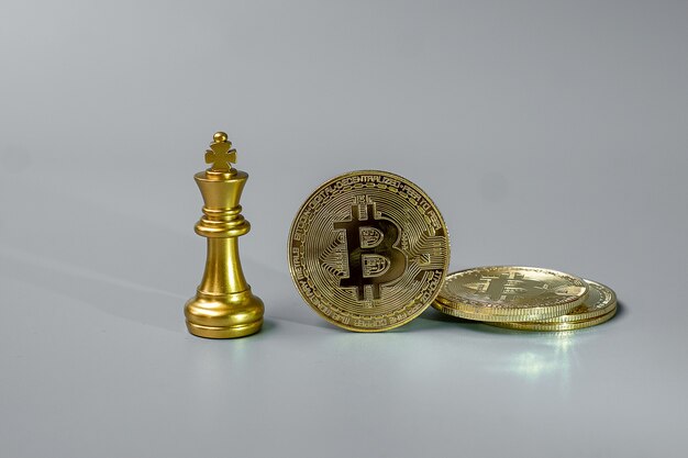 Pile de pièces de monnaie de crypto-monnaie Bitcoin d'or et pièce de roi d'échecs.