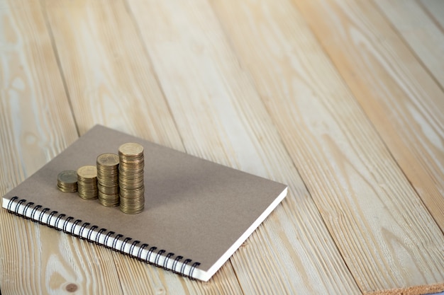 pile de pièces avec papier de cahier sur bois