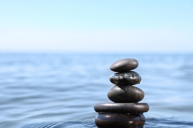 Pile de pierres dans l'espace d'eau de mer pour le concept Zen de texte