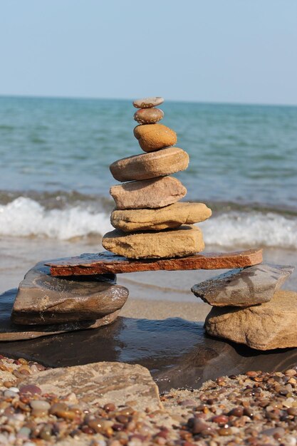 Photo une pile de pierres équilibrée sur la plage est apaisante à regarder.