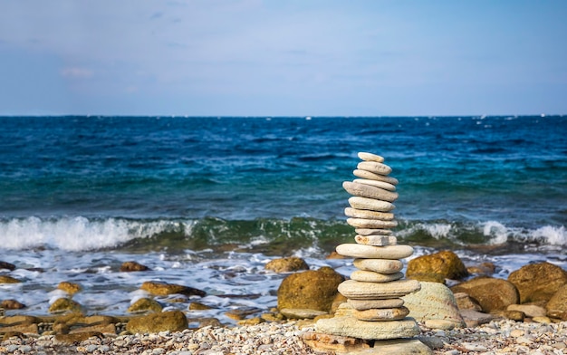 Pile de pierres sur la plage devant les vagues