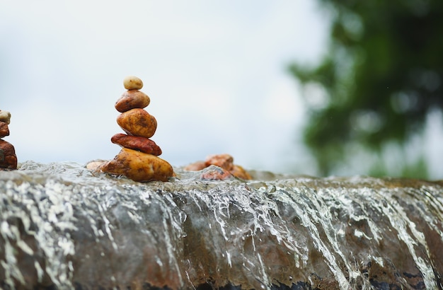 Pile de pierres zen sur cascade sur fond de tempête de nuages