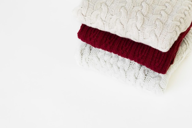 pile de pulls en laine chaude sur fond blanc espace pour le texte