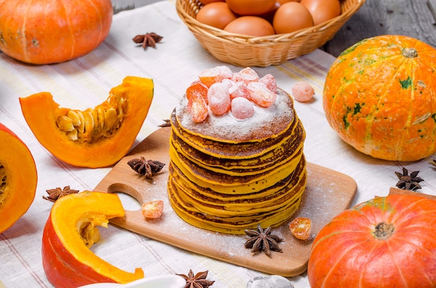 Une pile de punkcakes à la citrouille faits maison avec du sucre en poudre sur le dessus et du kumquat confit.