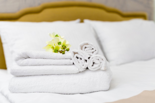 Pile de serviettes avec décor floral dans une chambre d'hôtel