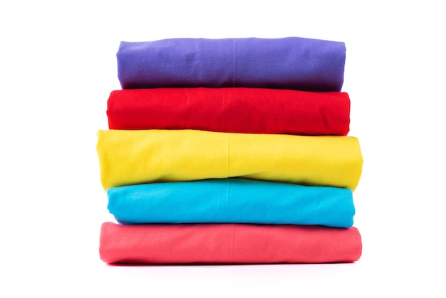 Une pile de T-shirts en coton colorés isolés sur fond blanc