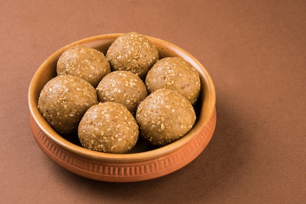 Pile de Tilgul Laddu ou Til Gul Laddoo fait à la main composé de jaggery ou de gud et de graines de sésame pour le festival Makar Sankranti, servi dans un bol. mise au point sélectionnée