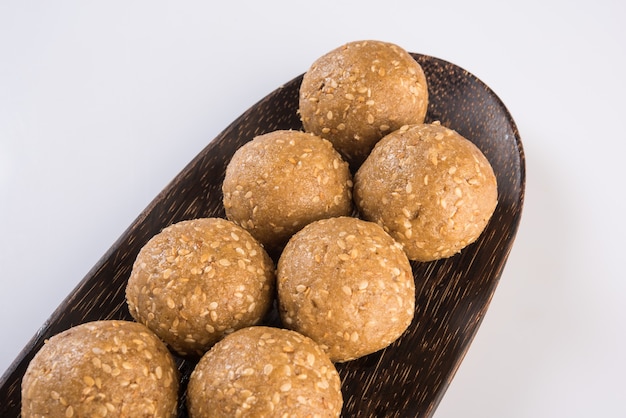 Pile de Tilgul Laddu ou Til Gul Laddoo fait à la main composé de jaggery ou de gud et de graines de sésame pour le festival Makar Sankranti, servi dans un bol. mise au point sélectionnée