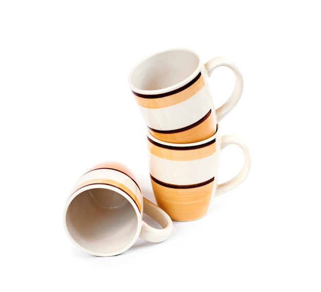 Pile de trois tasses isolé sur une surface blanche