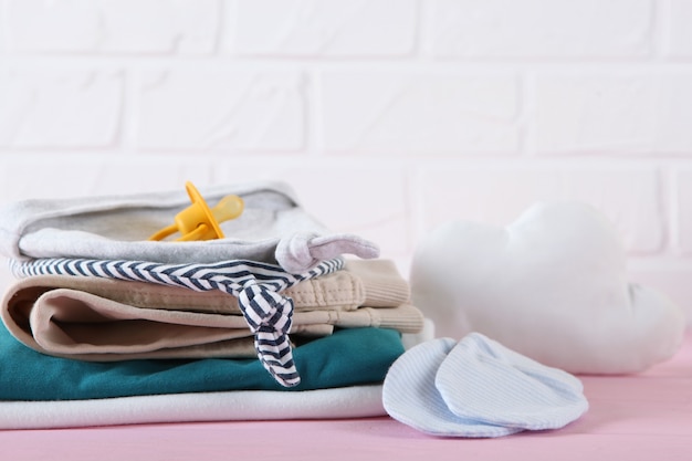 Une pile de vêtements de bébé sur fond clair