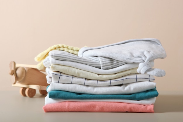 Une pile de vêtements de bébé sur fond clair