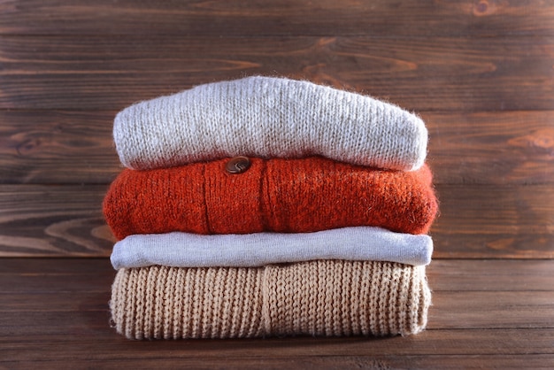 Pile de vêtements d'hiver chauds sur une surface en bois