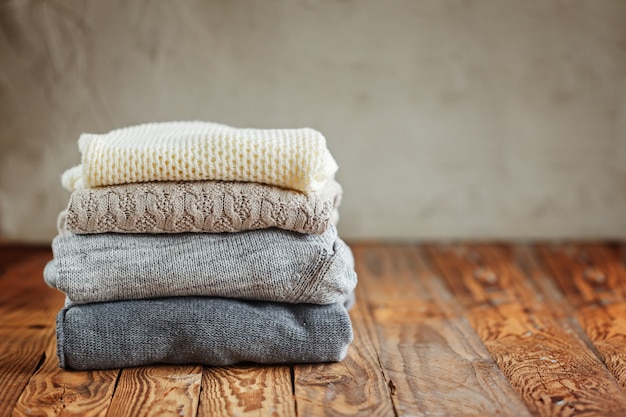 Pile de vêtements d&#39;hiver tricotés sur bois, chandails
