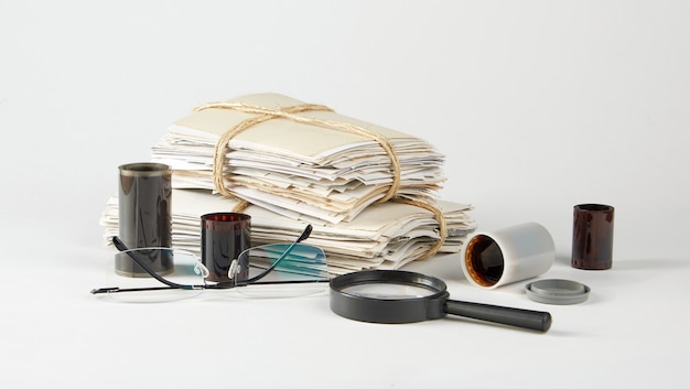 Une pile de vieilles photos verres négatifs et une loupe sur blanc