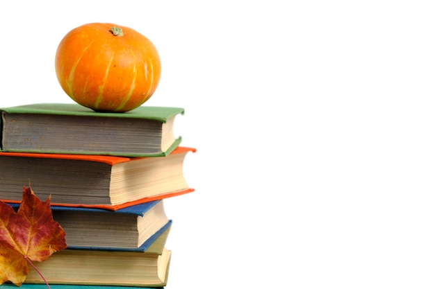 Pile de vieux livres citrouille et automne feuillage jauni fond blanc