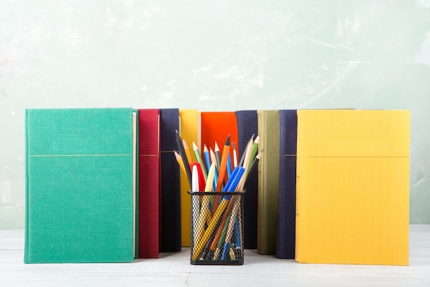 Une pile de vieux livres de couleur et de papeterie sur une table