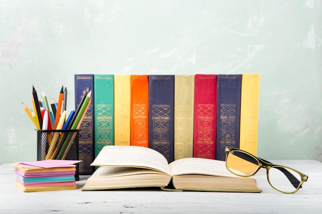 Une pile de vieux livres de couleur verres papeterie sur une table