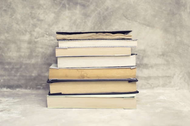 Pile de vieux livres sur une étagère en béton